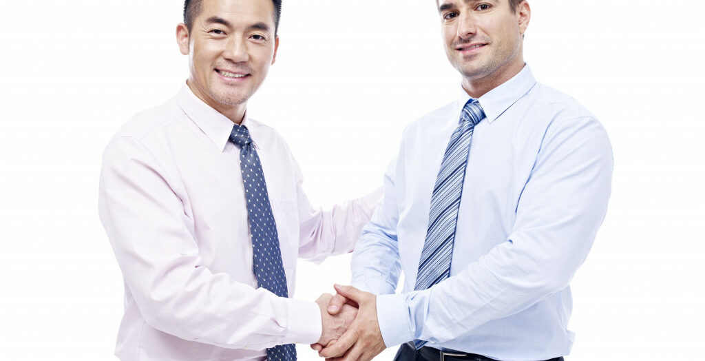 Two businessmen of different ethnicity shaking hands