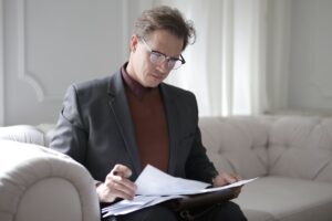 Classy executive male reading papers on couch