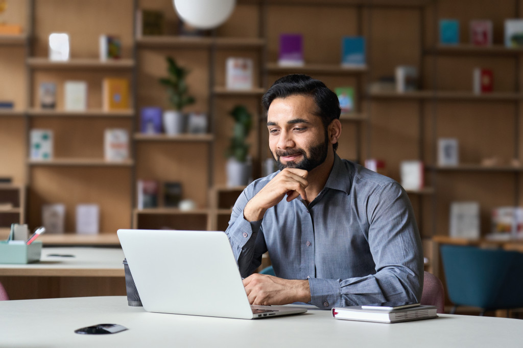 a man reading nline in his laptop