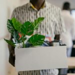 man carrying a box of personal items after resigning from his job