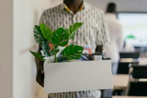 man carrying a box of personal items after resigning from his job