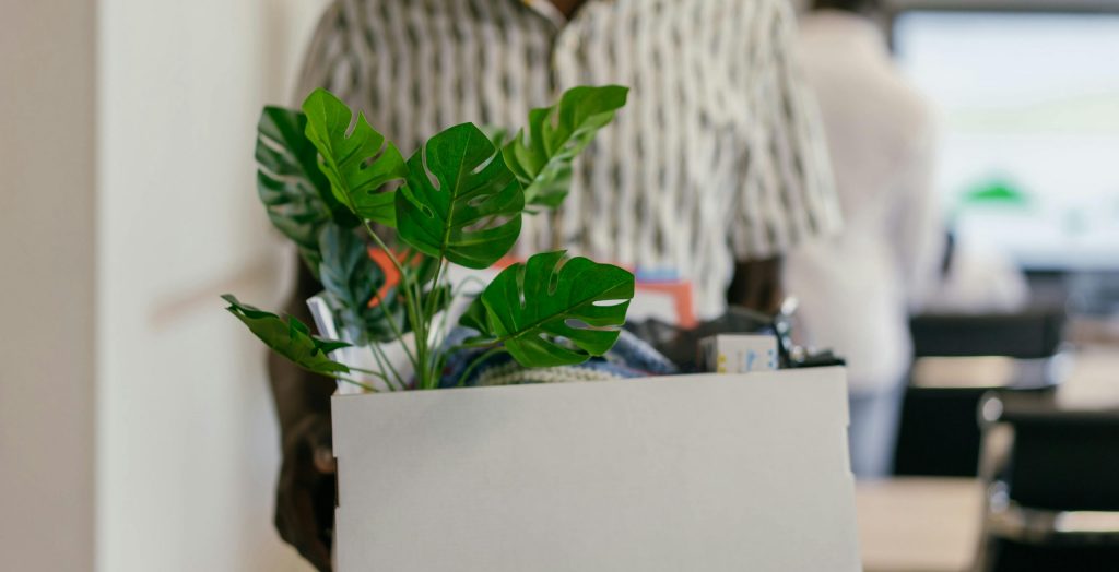 man carrying a box of personal items after resigning from his job