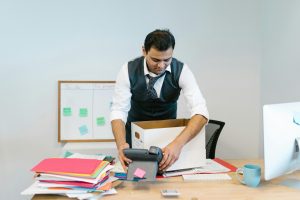 professionally dressed man packing up his desk
